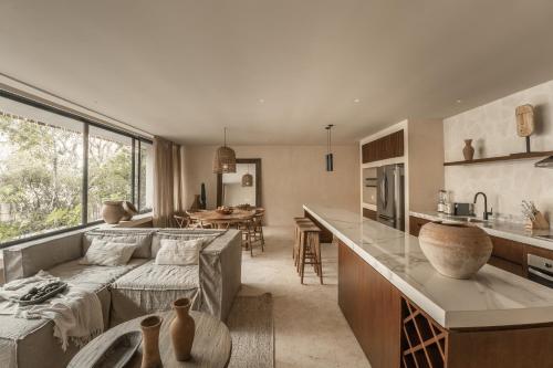 a kitchen and living room with a couch and a table at Exclusive Penthouse by Famous Interior Designer By Yeah in Tulum