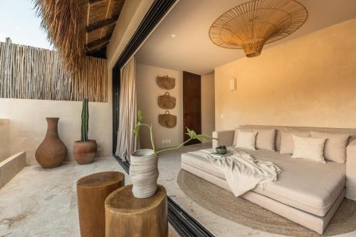 a living room with a white couch and a table at Exclusive Penthouse by Famous Interior Designer By Yeah in Tulum