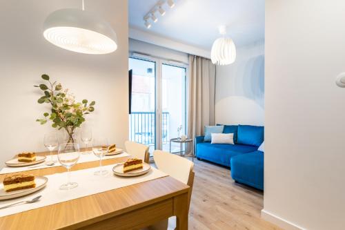 een woonkamer met een eettafel en een blauwe bank bij Parkcity Centrum in Katowice
