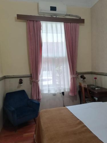 een slaapkamer met een bed en een blauwe stoel en een raam bij Private Room in Istanbul #57 in Istanbul