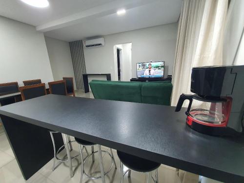 a black table with chairs and a television in a room at Novo central 2 quartos wifi/garagem/elevador in Foz do Iguaçu