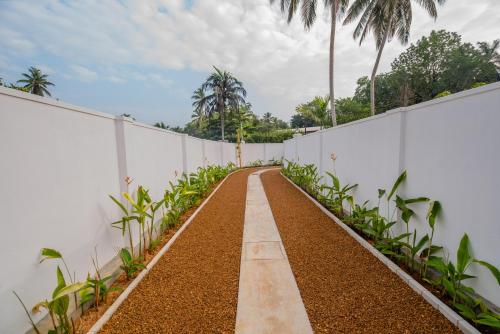 an empty pathway next to a white fence at Tree of Life Resort in Bentota