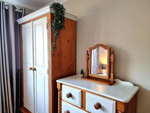 a mirror on top of a dresser in a bathroom at Stag Manor Hot Tub Retreat near Peak District in Crich