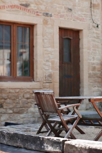 a couple of chairs sitting in front of a building at La Maison du Marcel in Sainte-Cécile