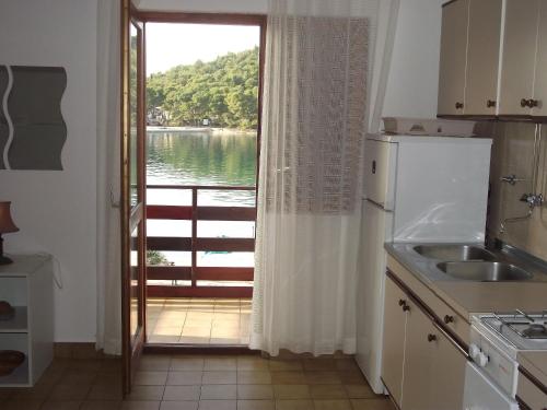 eine Küche mit einem Fenster mit Blick auf das Wasser in der Unterkunft Apartments Milo in Kukljica
