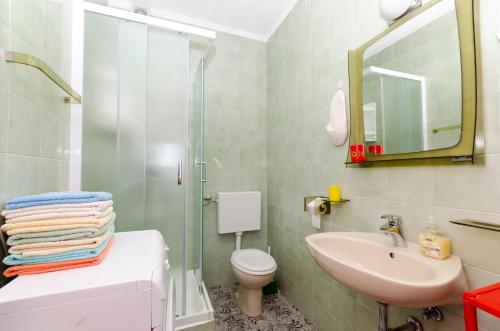 a bathroom with a sink and a toilet and a shower at Apartments Simon in Bol