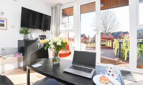 een laptop op een tafel in een woonkamer bij Chalet 47 By The Sea in Kingsdown