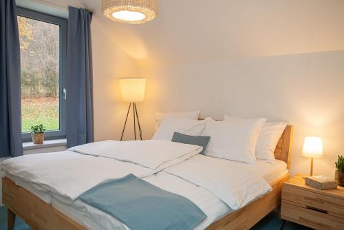 a bedroom with a large white bed with a window at Chata Jarabáček in Loučná nad Desnou