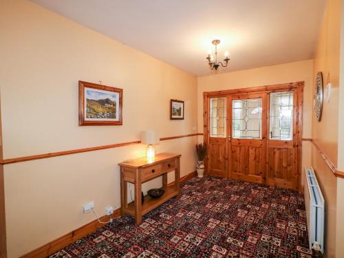 a living room with a table and a door at Willow Tree Farm House in Newry