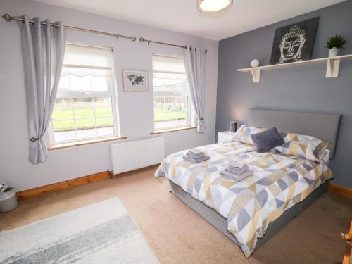 um quarto com uma cama e duas janelas em Willow Tree Farm House em Newry