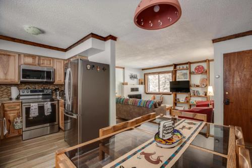 eine Küche mit einem Kühlschrank aus Edelstahl und einem Tisch in der Unterkunft Riverside Retreat 12 at Taos East in Taos