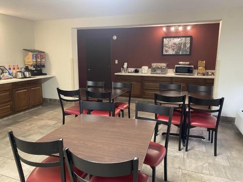 a restaurant with tables and chairs and a kitchen at Red Roof Inn Roanoke Rapids in Roanoke Rapids