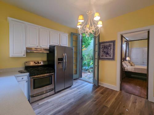 a kitchen with white cabinets and a stainless steel refrigerator at Villas de Frenchmen in New Orleans
