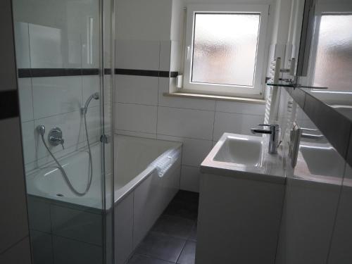 a bathroom with a shower and a tub and a sink at Ferienwohnung Schlossblick in Amtzell