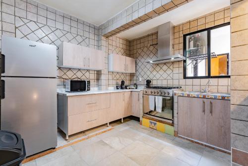 a kitchen with a refrigerator and a stove top oven at Casa Zamora by VH in Mexico City