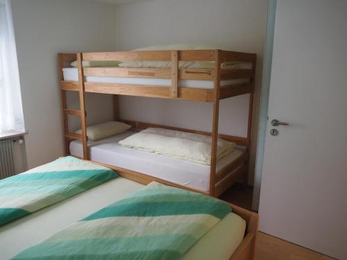 two bunk beds in a small room with a door at Ferienwohnung Schlossblick in Amtzell