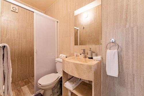 a bathroom with a sink and a toilet and a mirror at Casa Zamora by VH in Mexico City