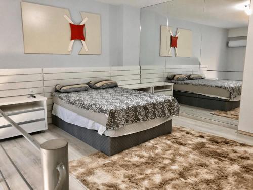 1 dormitorio con 2 camas y alfombra en Saint Sebastian Flat 213 - Com Hidro! até 4 pessoas, Duplex, no centro en Jaraguá do Sul