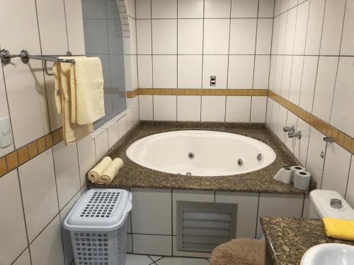 baño con bañera y cubo de basura en Saint Sebastian Flat 213 - Com Hidro! até 4 pessoas, Duplex, no centro en Jaraguá do Sul