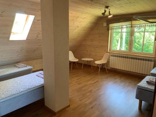 una habitación con 2 camas y 2 sillas en una cabaña en Topu kalurimaja, 