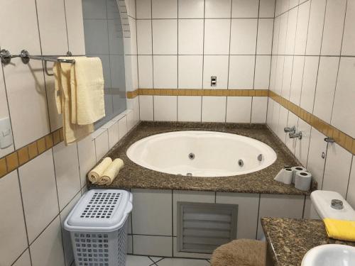 a bathroom with a tub and a trash can at Saint Sebastian Flat 506 - Com Hidro! até 4 pessoas, Duplex, no centro in Jaraguá do Sul