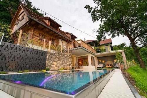 a house with a swimming pool in front of a house at Thombauer Hube in Sankt Johann im Saggautal