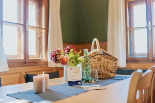 a table with two candles and flowers and a basket at Thombauer Hube in Sankt Johann im Saggautal
