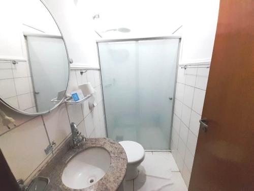 a bathroom with a sink and a mirror and a toilet at Hotel Itapema in Valinhos