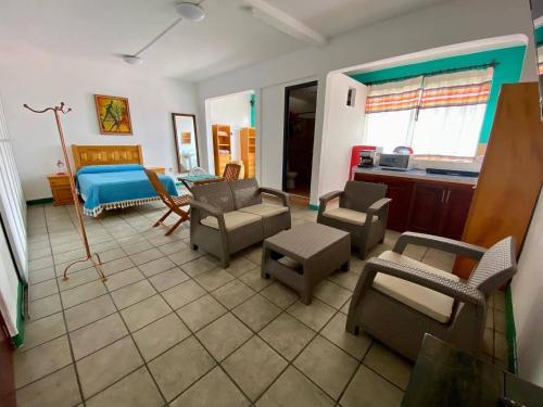 a living room with a couch and a bed and chairs at Hostal Mixteco Naba Nandoo in Oaxaca City