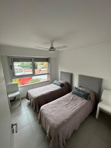 2 camas en una habitación con ventana en Centrico departamento de categoría en Chascomús