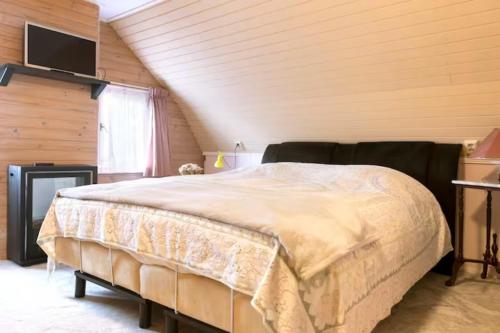 1 dormitorio con 1 cama grande en el ático en B&B Klassiek, en Twijzelerheide