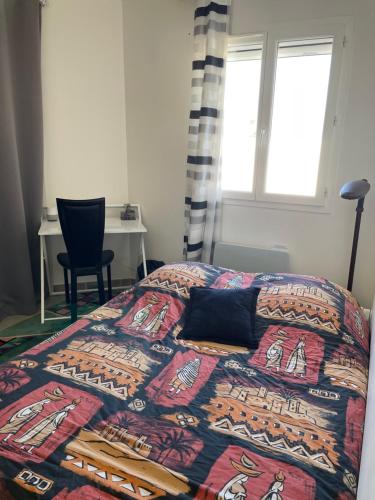 una camera da letto con un letto con un piumone colorato e una finestra di Chambre privée au cœur du Verdon a Saint-Julien