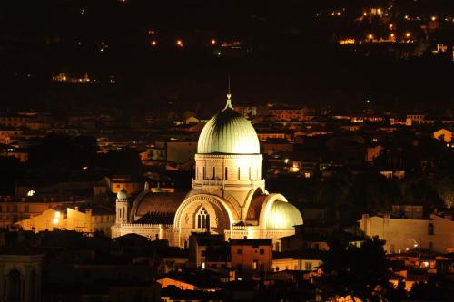 a large white building with a dome at night at Hotel d'Azeglio Firenze in Florence