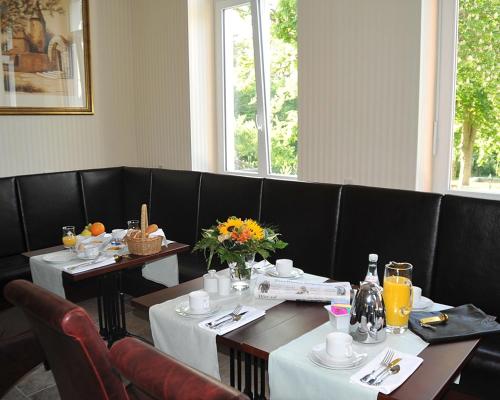 a dining room with two tables and chairs with flowers at Waldhotel Rheinbach in Rheinbach