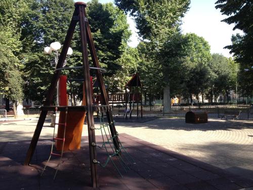 a playground in a park with a swing set at Hotel d'Azeglio Firenze in Florence