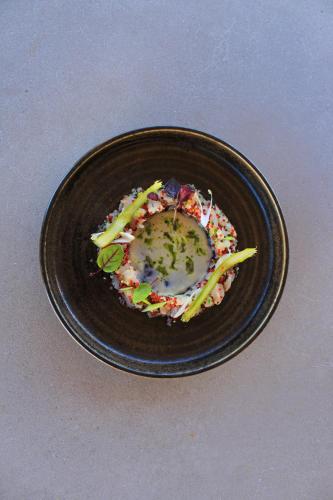 a black plate of food on a table at Adama Mykonos Boutique Hotel in Mýkonos City