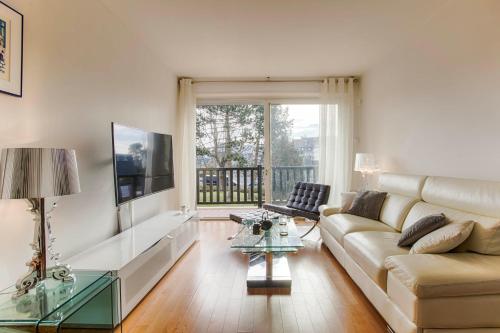 a living room with a couch and a glass table at La Villa Normande - One Bedroom in Deauville