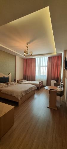 a large bedroom with two beds and a table at Hotel Antika in Peje