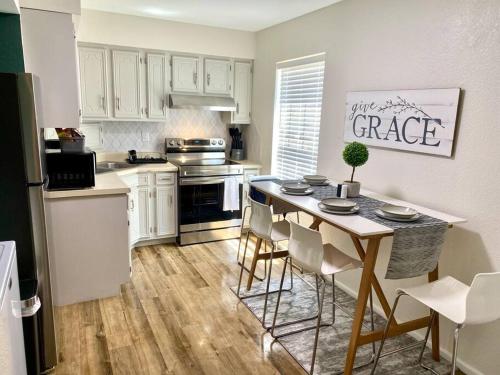 a kitchen with white cabinets and a table with chairs at Contemporary 2-Bedroom Rental Unit in Eagle Pass