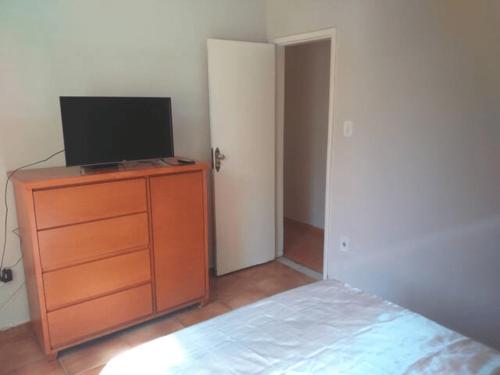 1 dormitorio con TV en la parte superior de un tocador en Apartamento(1) inteiro com sala reversivel en Volta Redonda