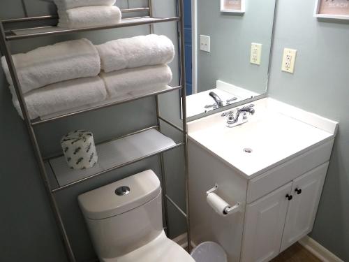 a bathroom with a toilet and a sink with towels at 1J Golf Colony Resort in Family Friendly Surfside in Myrtle Beach