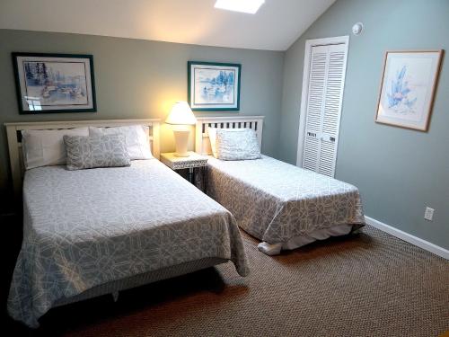 a bedroom with two beds and a lamp in it at 1J Golf Colony Resort in Family Friendly Surfside in Myrtle Beach