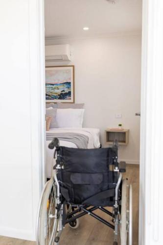 a wheelchair in front of a bedroom with a bed at Port Lincoln Beachfront Apartment 7 in Port Lincoln