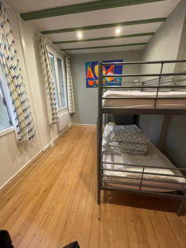 a room with two bunk beds and a wooden floor at GÎTE LES VOLETS BLEUS in Yport
