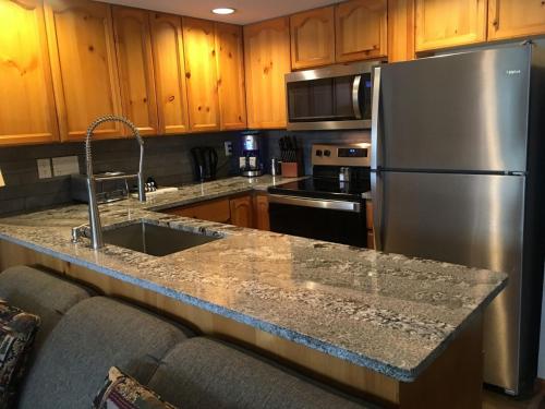 a kitchen with a stainless steel refrigerator and wooden cabinets at Valhalla Vacations at Whistler in Whistler