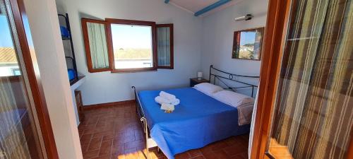 um quarto com uma cama com um urso de peluche em Sa Domu Tabarchina em Calasetta