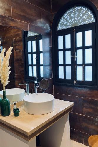 a bathroom with two sinks and a window at Riad Ksar Saad & Spa in Marrakech