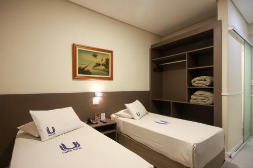 a hotel room with two beds and a shelf at Hotel Itamarati Centro-República in Sao Paulo