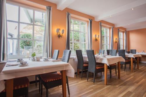 a dining room with tables and chairs and windows at Boutique-Hotel Weigels Bergfreiheit in Winterberg