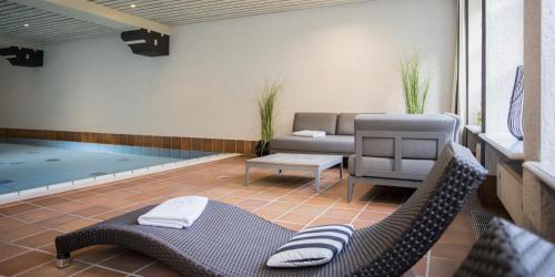 a patio with a couch and chairs and a pool at Boutique-Hotel Weigels Bergfreiheit in Winterberg